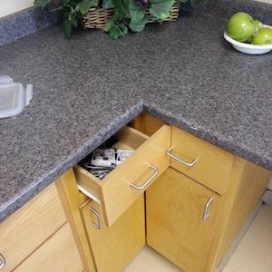 two corner drawers, each with a handle that blocks the other from opening